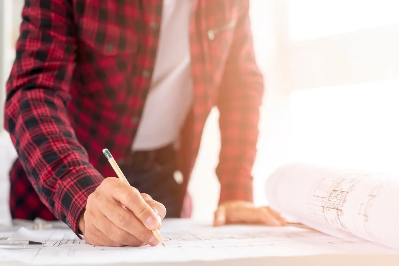 Mittlere Einstellung eines Mannes beim Zeichnen eines Architekturprojekts.